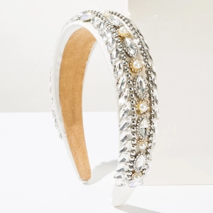 Detail of baroque headband with crystals and pearls on white satin fabric