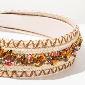 Close-up of mixed color woven headband with amber rhinestones and stitching details