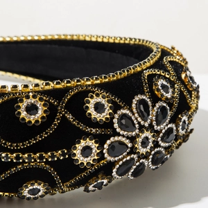 Close-up of black velvet Baroque headband with hand-sewn crystals and gold floral settings