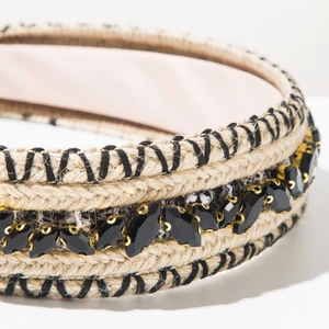 Detail view of woven knit headband with sparkling crystals and golden metal claw clasps