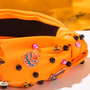 Detailansicht des orangen Haarreifens mit Perlenkürbissen und Geistern für Halloween