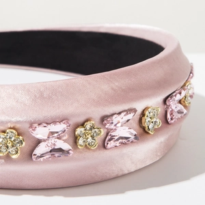 Détails du serre-tête en satin rose orné de papillons en cristal et strass dorés