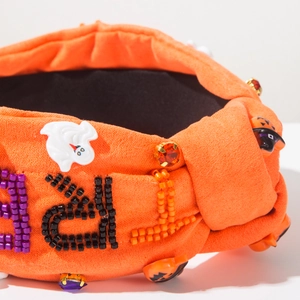 Detail of Halloween headband with orange suede, beaded letters, ghost and pumpkin charms