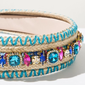 Close-up of bohemian hand-woven headband with colorful rhinestones and blue embroidery