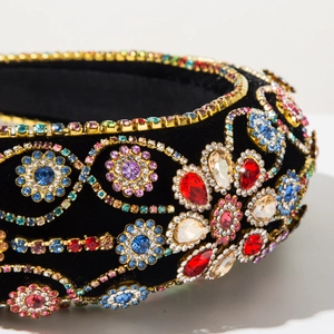 Macro detail of Baroque headband with colorful crystals and rhinestones on black velvet