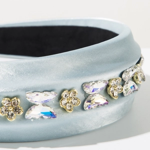 Détail du serre-tête en satin bleu clair orné de papillons et motifs floraux en strass brillants