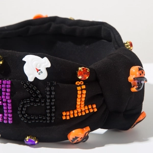 Close-up of Halloween headband with beaded letters, ghost and pumpkin resin charms