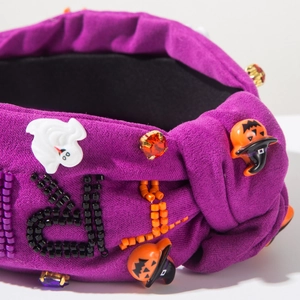 Close-up of Halloween headband with purple fabric, beaded pumpkin and ghost charms