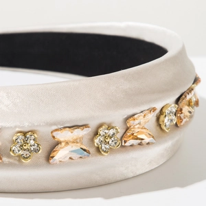 Gros plan détaillé du serre-tête rembourré en satin champagne avec strass scintillants