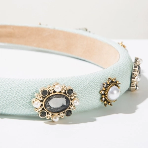 Close-up of vintage mint fabric headband with pearl and gemstone embellishments