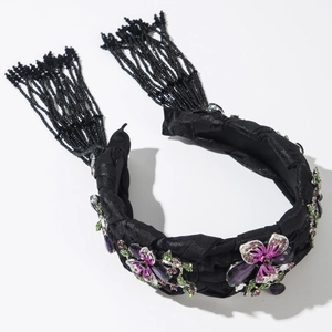 Details des geflochtenen schwarzen Satin-Haarreifs mit Strassblumen und langen Perlenquasten