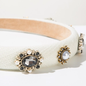 Detail of vintage fabric headband with pearl and diamond embroidery on mint knit material