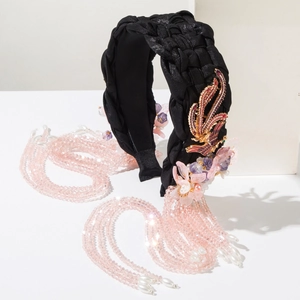 Detail of hand-woven black satin headband with phoenix metal charm and crystal tassels