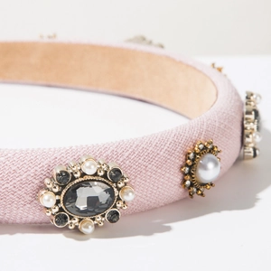 Macro view of pink fabric headband featuring vintage pearl and crystal embellishments