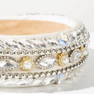 Macro shot of Baroque headband featuring intricate crystals and luxury pearls on satin fabric