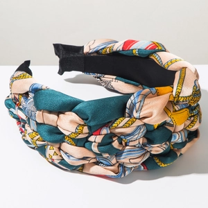 Macro detail of Bohemian braided headband featuring vintage chain prints and satin texture