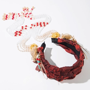 Detail of red braided headband with gold floral accents and long beaded tassel fringe