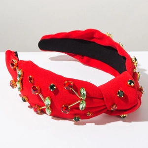 Dettaglio del cerchietto a nodo rosso con ciliegie in strass e gemme colorate brillanti