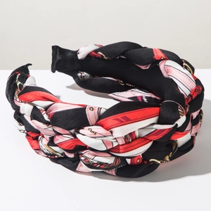 Detailed view of wide braided headband with red and black retro chain print on satin fabric