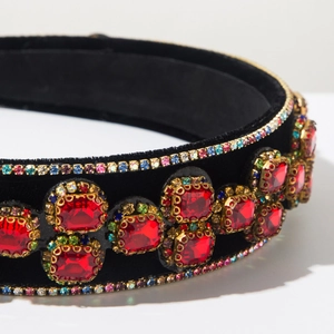 Macro shot of luxury velvet baroque headband with red crystals and gold rhinestones
