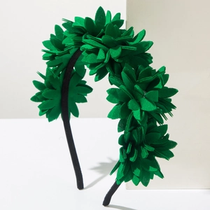 Detail of green fabric flower headband with 3D petals and elegant pearl accents