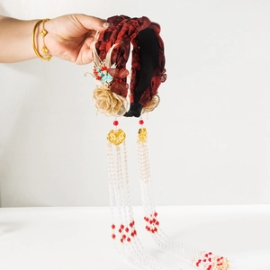 Detail of red Chinese headband with golden phoenix accents and long pearl tassels
