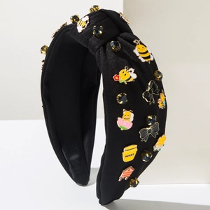 Detail eines schwarzen Stoffhaarreifens mit Bienen, Blumen und Kristallen