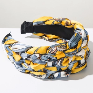 Macro detail of Bohemian braided headband featuring yellow and blue vintage pattern