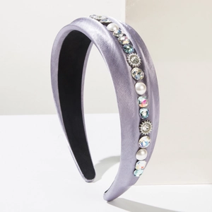 Detail view of purple satin headband with sparkling rhinestones and white pearls