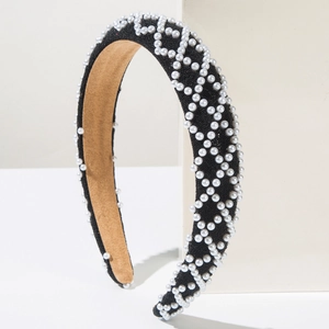 Close-up of black velvet headband with white pearls in geometric diamond patterns