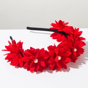 Close-up of handmade red fabric flowers with white pearls on a black fashion headband