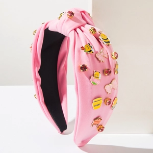 Detail eines rosa geknoteten Stirnbands mit Emaille-Bienen und glitzernden Kristallen