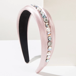 Detail view of pink satin headband with glossy pearls and sparkling colorful rhinestones