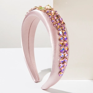 Detail of pink satin headband with gradient rhinestones and golden insect buckle