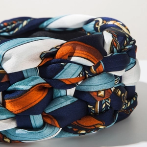 Detailed macro view of woven satin headband featuring chain and equestrian patterns