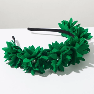 Close-up of green fabric flower headband featuring elegant grey pearl bead centers