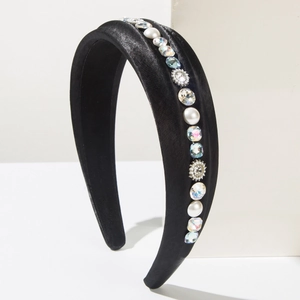 Macro view of black velvet headband with white pearls and sparkling rhinestone details