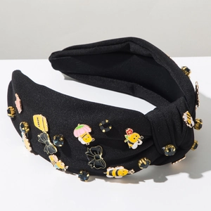 Detailaufnahme von schwarzem Stirnband mit Emaille-Bienen, Blumen und Strasssteinen