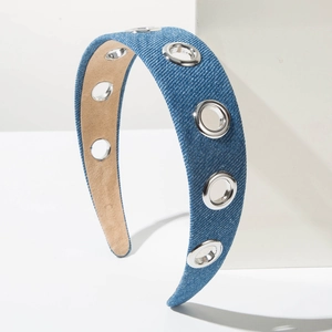 Close-up of blue denim headband featuring large silver metal eyelets and a C-shaped frame