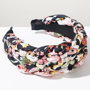 Detail of floral braided headband showing textured fabric weaving and non-slip inner lining