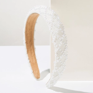 Detailed side view of white wide padded headband with elegant pearl lattice embroidery