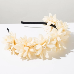 Detail of handmade cream 3D fabric flowers with pearls on a black fashion headband