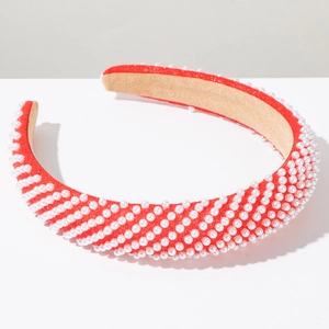 Detail of red padded headband with white faux pearls in a diagonal striped pattern