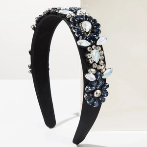 Détail du serre-tête baroque avec strass bleus sur tissu satiné noir rembourré
