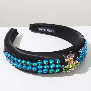 Detail of black satin headband with blue gems and crystal frog accessory embellishment
