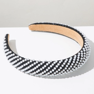 Detail of wide padded pearl headband featuring black shimmer fabric and non-slip velvet lining