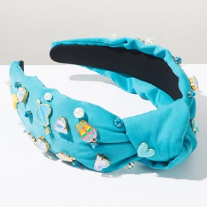 Detalle de la diadema anudada azul claro con perlas y pedrería en forma de corazón