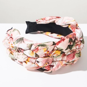 Close-up of pink floral braided headband showing fabric texture and woven details