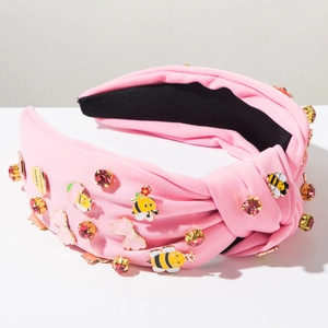 Nahaufnahme von rosa geknotetem Haarreif mit Emaille-Bienen und funkelnden Strasssteinen