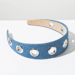 Detail of blue denim wide headband featuring metallic silver eyelets and soft lining texture